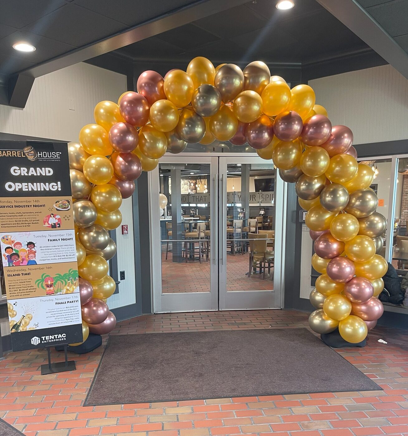 Gold, champagne, and rose balloon archway for a grand opening